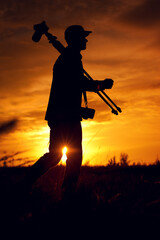 Silhouette of photographer with camera and tripod