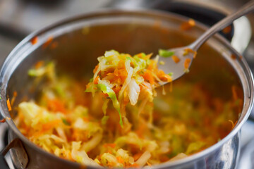 Braised cabbages with carrot in a pan