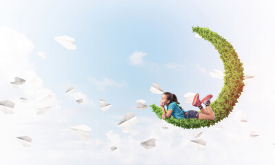 Concept of careless happy childhood with girl dreaming about som