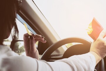 Lady eating french fries white driving car dangerously