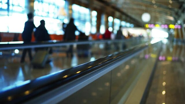 4k Ultra hd shot of travalator in airport madrid. People with luggage bags and backpacks move by it. Big depth of field blurred background view.