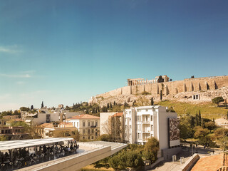 Obraz na płótnie Canvas Beautiful view of Acropolis of Athens with people enjoying their coffee.