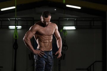 Obraz na płótnie Canvas Muscular Bodybuilder Showing His Front Abdominal Abs