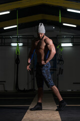 Obraz na płótnie Canvas Handsome Muscular Man Flexing Muscles In Gym