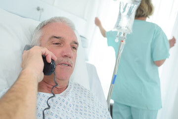 Patient in hospital bed on telephone