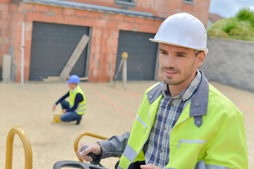 Man using equipment outdoors on building site