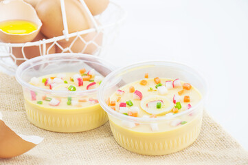 Thai steamed egg with fresh beaten egg in a basket decoration on sack background
