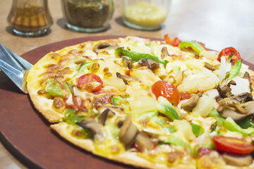 Pizza with colorful vegetable topping ready to be eaten