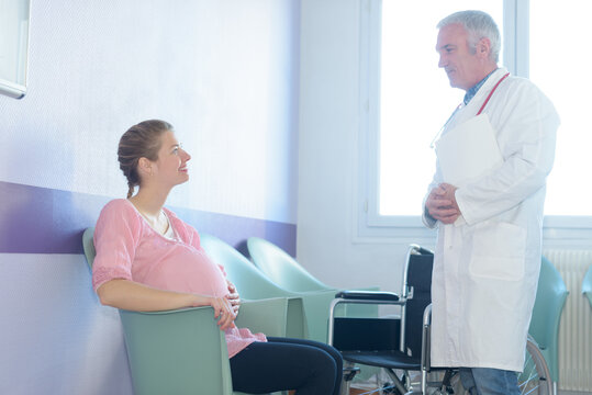 Doctor greeting pregnant woman in waiting room