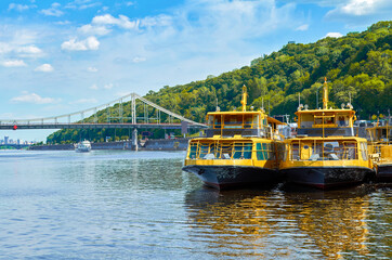 Fototapeta na wymiar Tourist boats on the river quay in Kiev on a tour of the Dnieper, Kiev, Ukraine.