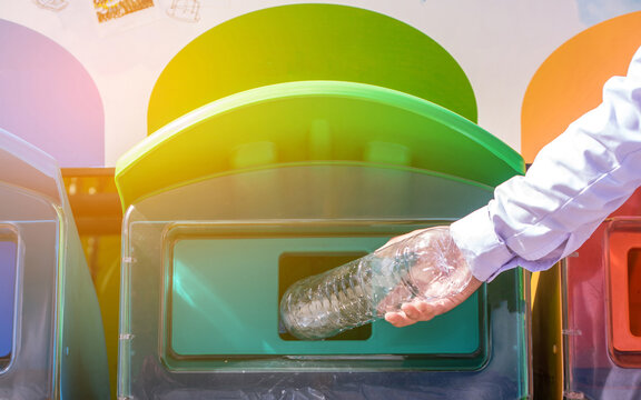 Selective Focus Hand Throwing Empty Plastic Bottle Into The Trash.