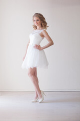 Naklejka premium girl in a wedding dress stands in a white room wedding