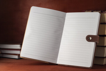 A notebook with textbooks on a wooden table.