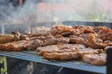 barbecueing on beautifull sunny day. steaks, chicken legs close-up