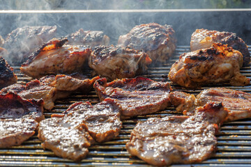 barbecueing on beautifull sunny day. steaks, chicken legs close-up