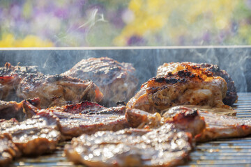 barbecueing on beautifull sunny day. steaks, chicken legs close-up