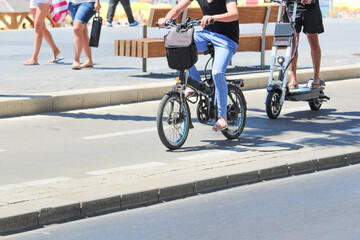 Two men riding on electric bicycles and electric scooter