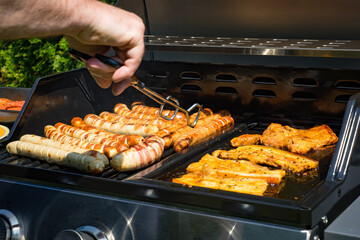 Grillfest im Garten - Grillwurst und Bauchspeck auf dem Grill