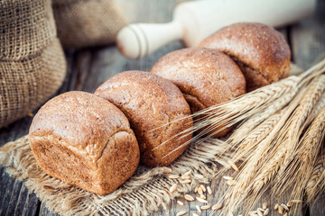 Fresh bread, wheat ears, sack of flour and rolling pin.