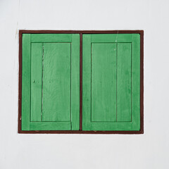 green wood window frame on white wall by walkway
