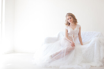 Fototapeta na wymiar beautiful girl in lingerie sitting on a white couch wedding