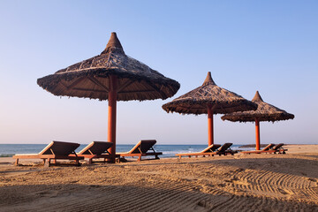 Зонты и лежаки на морском пляже.