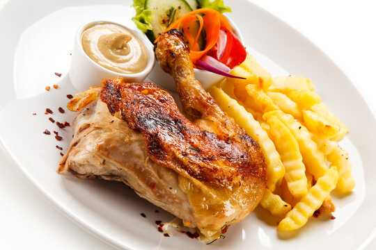 Roast chicken leg with french fries on white background 