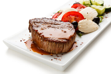 Grilled steak with mozarella and vegetables on white background 