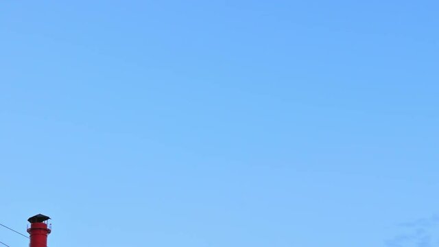 Chimney smoke / Smoke stack / Power plant. Panning along power lines to the smoking red-white chimney of thermoelectric plant.