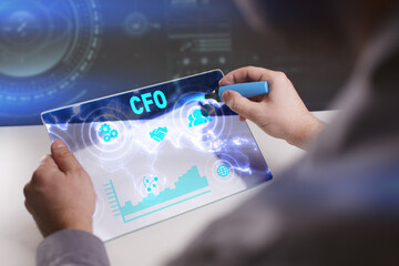 Business, Technology, Internet and network concept. Young businessman working on a virtual screen of the future and sees the inscription: CFO