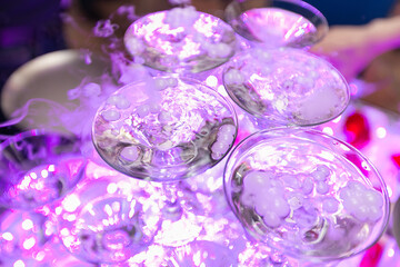 Pyramid of glasses with champagne with smoke.