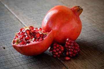 Ripe pomegranate fruit on wooden vintage background.