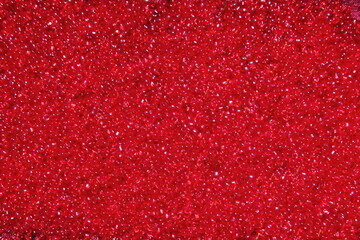Crimson-red glass beads background - closeup beads texture