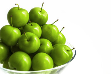 Green sour plums in the plate, plum pictures on the white ground,
Quality and natural life-giving green sour plums

