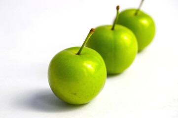 Sour plum pictures on white ground, wonderful sour plums, green plums pictures from the first fruits in summer
