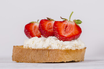 Sandwich of strawberry and cottage cheese on the wooden table, close up