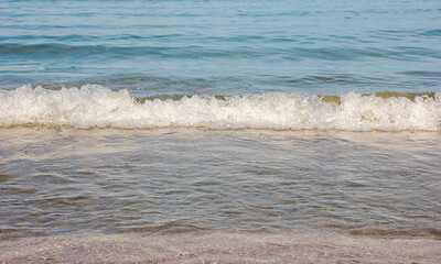 the concept of summer vacation on the beach. sea wave comes to the sandy shore