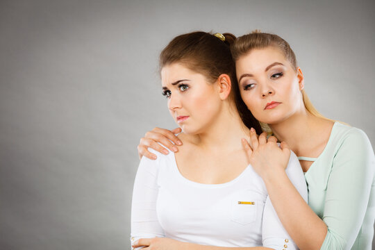 Woman hugging her sad female friend