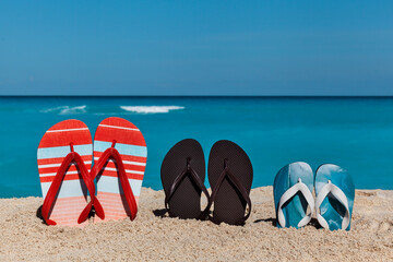 Flip flops on the sand beach with blue sea and sky background