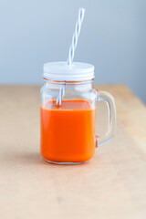 Fresh carrot juice in the jar on table