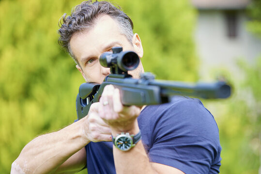 Aiming at a target. Shot of a man with airgun practicing at the shooting range. 