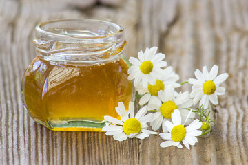 jar of honey and chamomile flowers