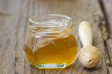 jar of honey and wooden dipper