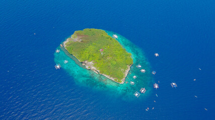 Fototapeta premium Aerial view of sandy beach with tourists swimming in beautiful clear sea water of the Sumilon island beach landing near Oslob, Cebu, Philippines. - Boost up color Processing.