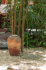 Obraz premium Vintage and retro grunge jar next to bamboo tree in park.