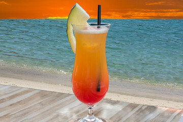 Cocktail Tequila sunrise blaues Meer im Hintergrund.