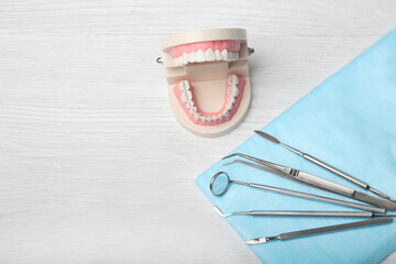 Dental jaw model and tools on wooden background