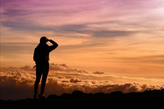 Tourist admiring breathtaking sunset views from the Mauna Kea, a dormant volcano on the island of Hawaii