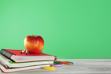 School stationery with apple on green background
