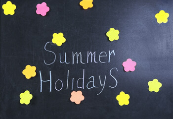 "Summer holidays" text with stickers on chalkboard